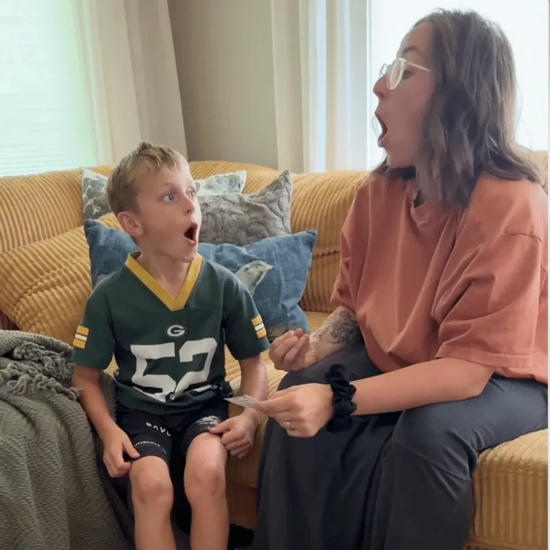 A mom and her son making silly shocked faces on the couch