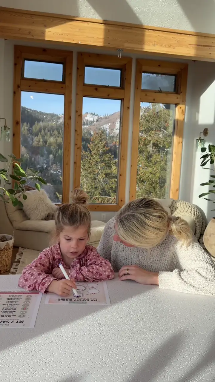 A child filling in the My Safety Circle worksheet at the table