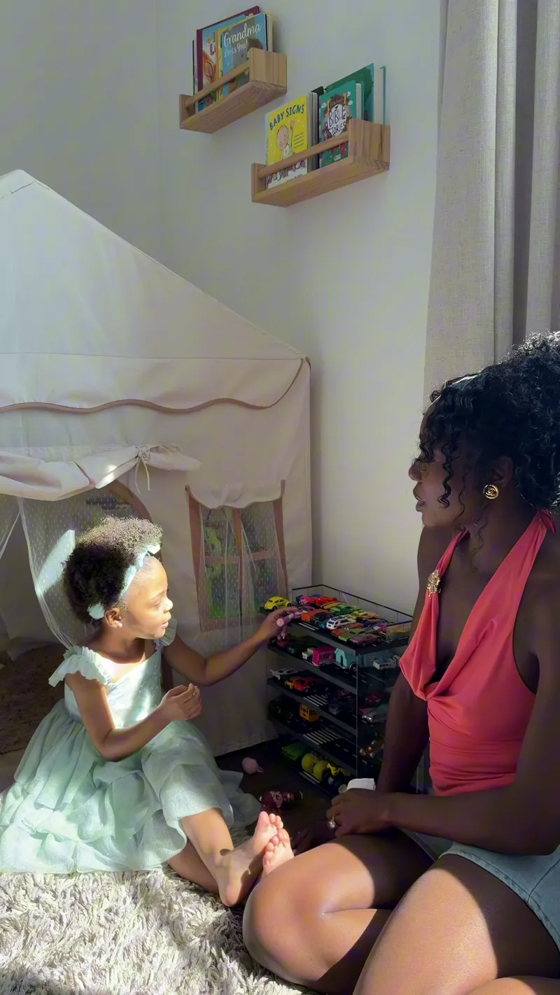A mom and her toddler daughter with the cards in a play tent