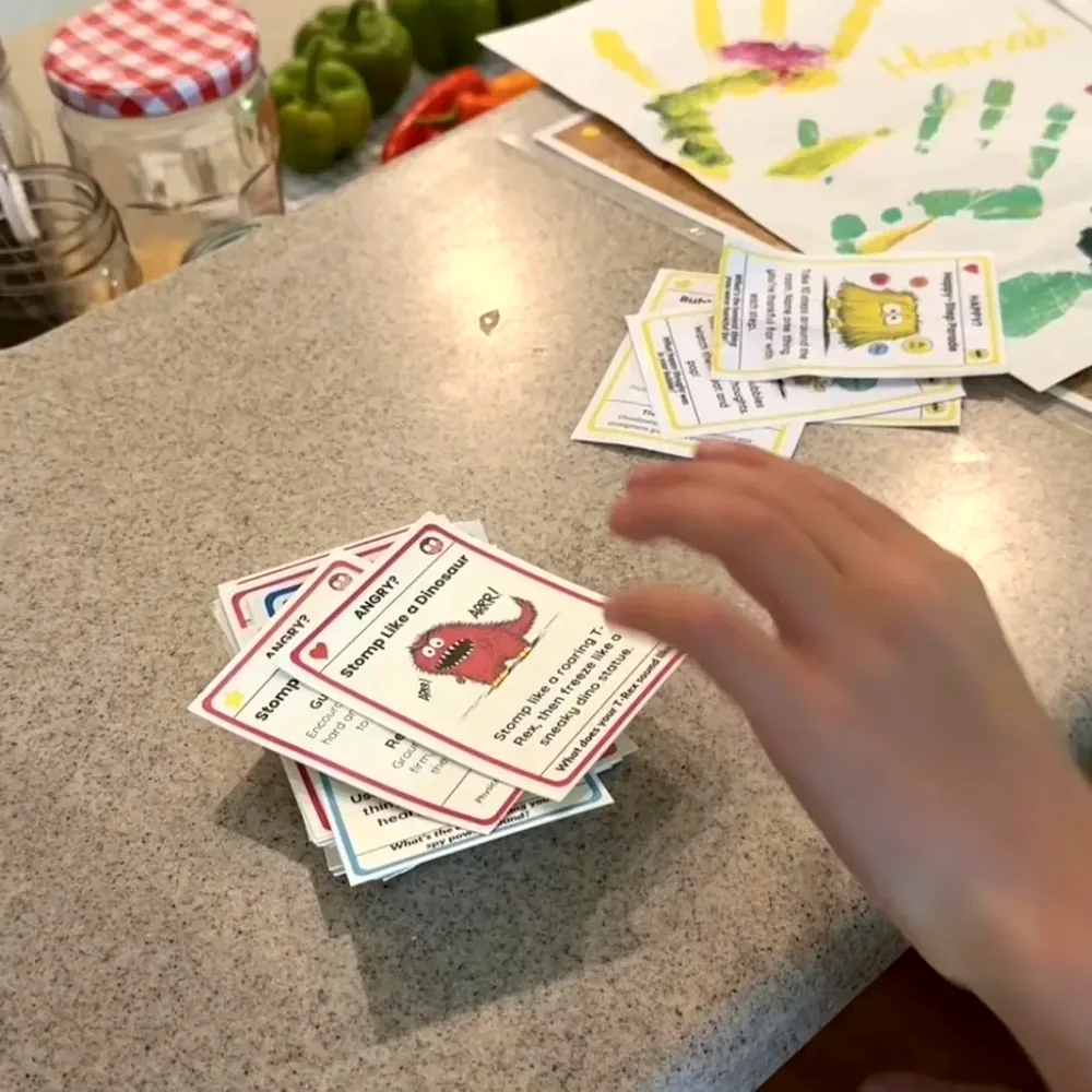 A kid flipping through the Big Feelings Deck on the kitchen counter
