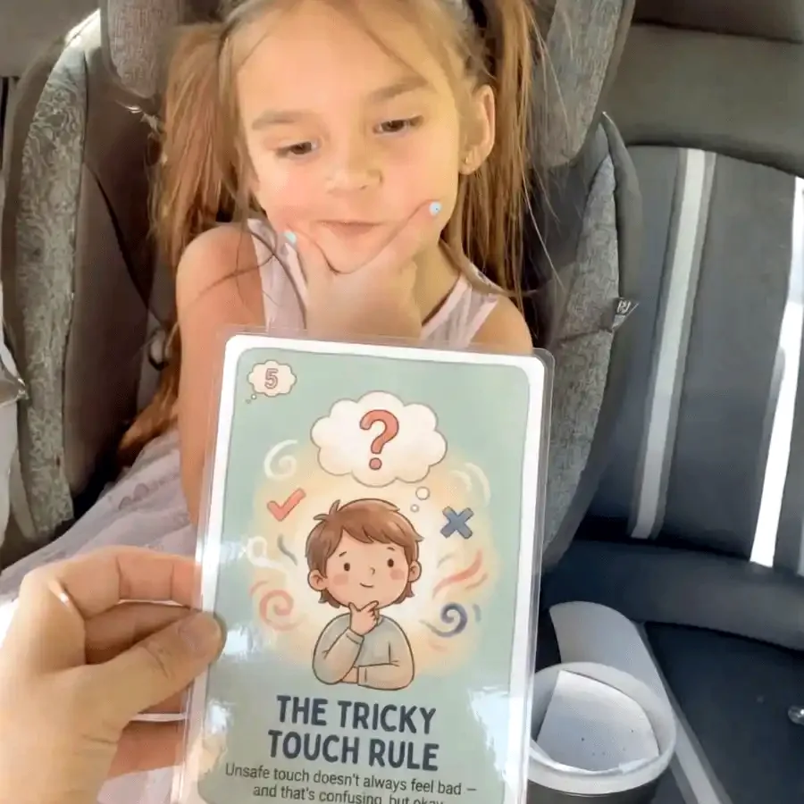Jessica's daughter in the back seat, holding up the Tricky Touch Rule card from the Body Safety deck